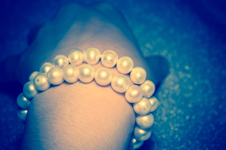 Beaded bracelet made of fresh water pearls, filtered background.の写真素材