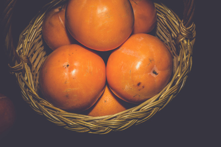 Delicious ripe persimmon, juicy orange fruits on black background, filtered.の写真素材