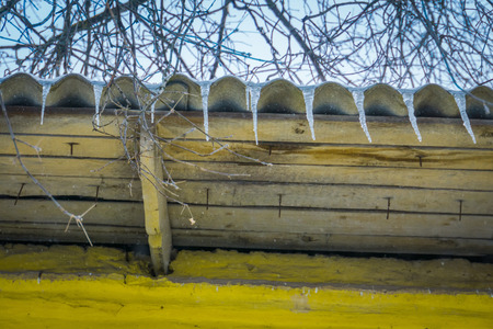 Row of small icicles on the roof of the house.の写真素材
