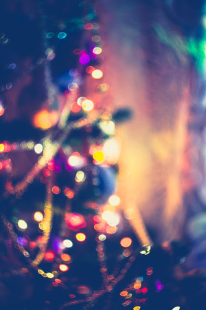 Decorated Christmas tree and colorful garland lights, defocused background, bokeh effect.の写真素材