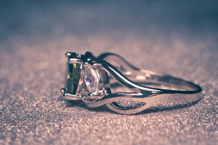 Precious golden ring decorated with green stone, zirconia, filtered.の写真素材