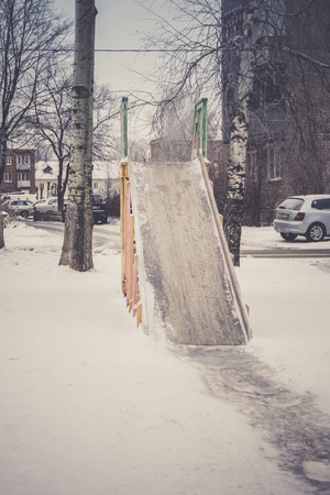 Wooden children's slide on the playground in the winter.の写真素材
