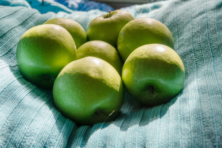 Pile of ripe green apples close up background.