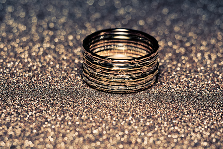 Fashion golden ring over glittering background, macro, vintage effect.の写真素材