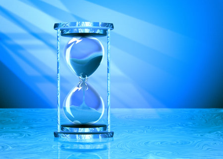 Decorative vintage style hourglass on a wooden table background.