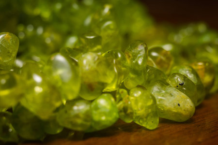 August birthstone olive green peridot, natural stone gravel close up.