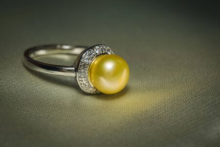 Luxury silver ring with natural freshwater pearl of yellow color, macro.の写真素材