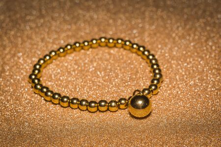 Fashion bracelet made of gold round beads background.の写真素材