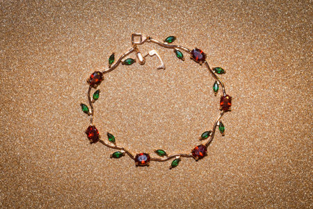 Decorative rose gold bracelet with ruby red and green zircons, floral themed jewellery.