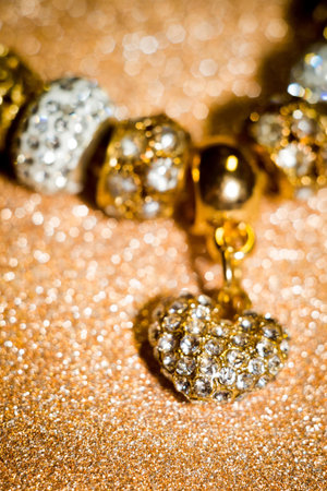Fashion bracelet with decorative silver and gold charms background.