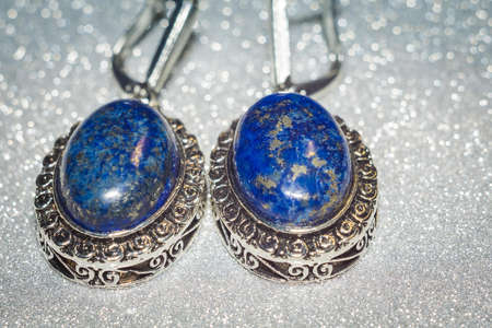 Vintage silver earrings with natural stone, blue lapis lazuli background.の写真素材