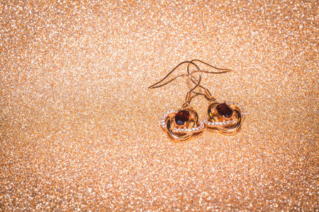 Fashion golden earrings with a dark red garnet stone.の写真素材