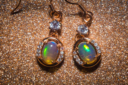 Fashion golden earrings with a bright rainbow flash opal stone.の写真素材