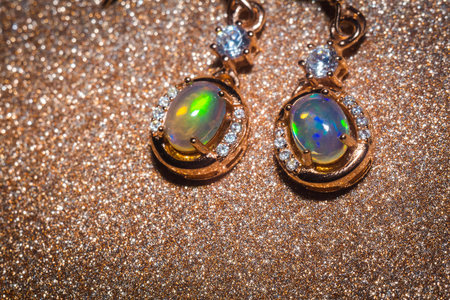Fashion golden earrings with a bright rainbow flash opal stone.の写真素材