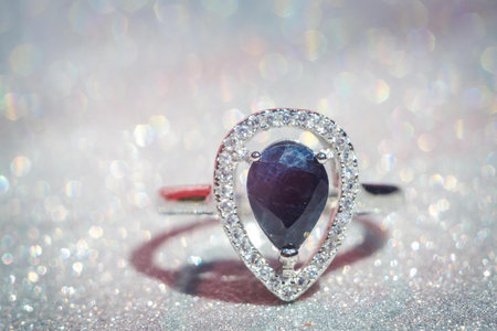 Fashion silver ring with natural black sapphire on glitter background.の写真素材