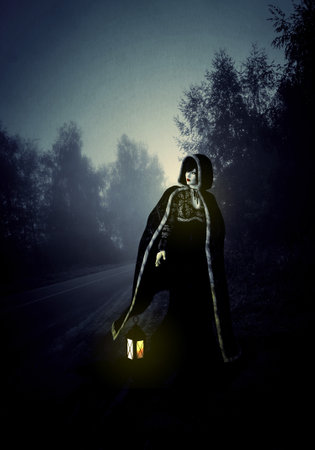 Lone woman with ancient lantern wear hooded cloak walk on the night foggy road, 3d Illustration.の写真素材