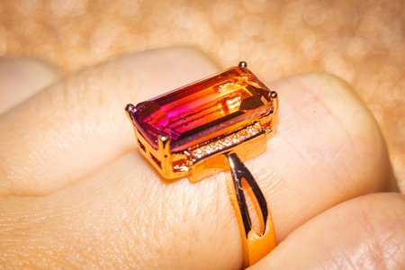 Fashion golden ring with pink yellow stone, close up background.の写真素材
