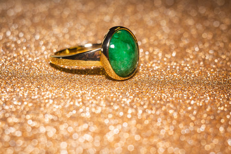 Fashion golden ring with green stone, close up background.の写真素材