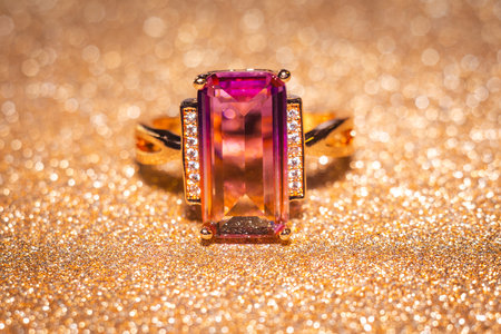 Fashion golden ring with pink yellow stone, close up background.の写真素材