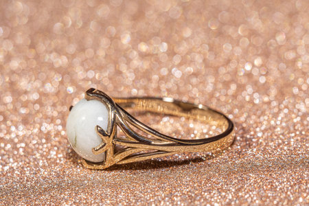 Close up of fashion golden ring decorated with white goshenite. Gold ring with natural goshenite stone.の写真素材