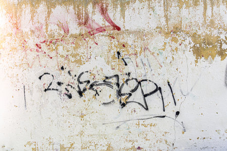 Distressed white paint on the wall with some graffiti, abstract texture as grunge background.の写真素材