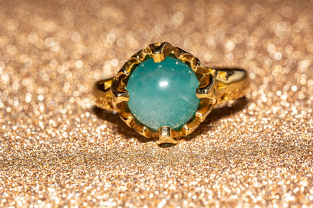 Yellow gold ring with dark blue aquamarine, Beryl stone. Round shaped beaded stone. Macro photo over...