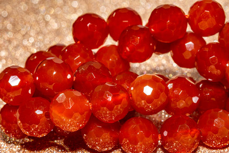 Beautiful red carnelian beads in macro photography, perfect for crafting and jewelry design. Decorative faceted carnelian stone beads for boho jewelry.の写真素材