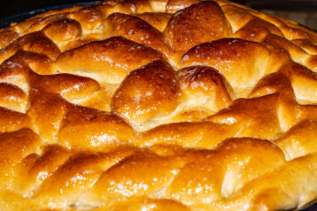 Close-up food photography of baked decorative yeast dough pie in a round shape.の写真素材