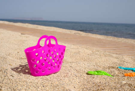 Pink plastic beach bag on the sandの写真素材