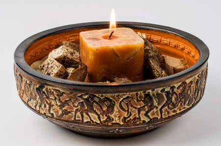 Decorative arrangement with a lighted candle in a Greek bowl for aromatherapyの写真素材