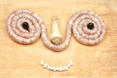 Funny food figure made of sausages, olives and beansの写真素材