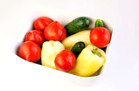 White bowl with assorted fresh vegetables on white backgroundの写真素材