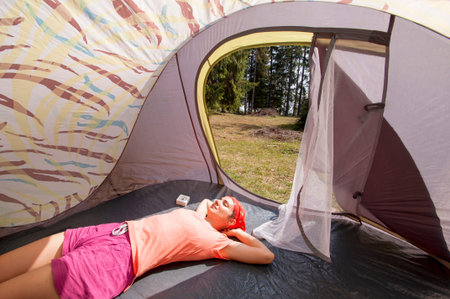 Young woman relaxing in the tent in the mountains