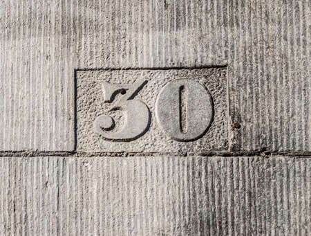 Number 30 carved in the gray wallの写真素材