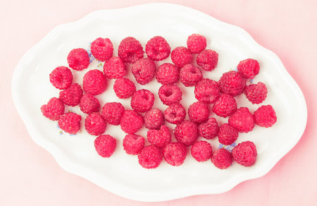 Fresh and delicious raspberries in a white plate