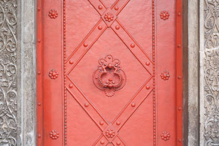 Vintage red metal door with door-knocker in a cemetery, detailの写真素材