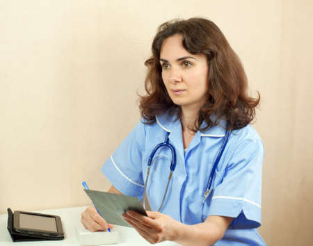 Woman doctor in blue uniform with X-ray, isolatedの写真素材