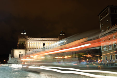 Altar of the Fatherland or Monumento Nazionale a Vittorio Emanuele II (National Monument to Victor Emmanuel II) in Rome, Italy, with night trafficの写真素材