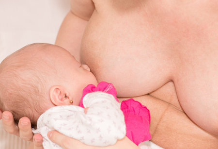 The woman who holds the baby in his arms and nurses him