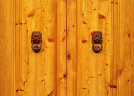 Detail of a wooden door with two metal lionsの写真素材
