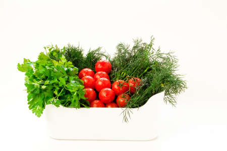 White bowl with fresh tomatoes, dill and parsley on white backgroundの写真素材
