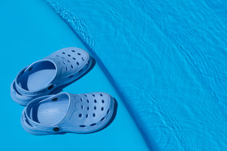 A pair of blue slippers near the pool