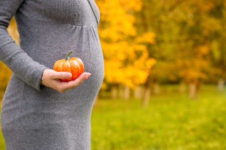 Young pregnant woman holding a gourd, isolatedの写真素材