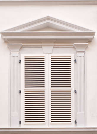 White window with shutters on white wallの写真素材