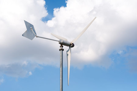 Wind energy turbine against blue, cloudy sky
