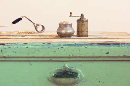 Old Turkish manual grinder, immersion heater and wheat on a wooden tableの写真素材