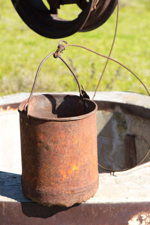 An old rusty bucket on a fountainの写真素材