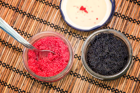 Two jars with lumpfish caviar red and blackの写真素材