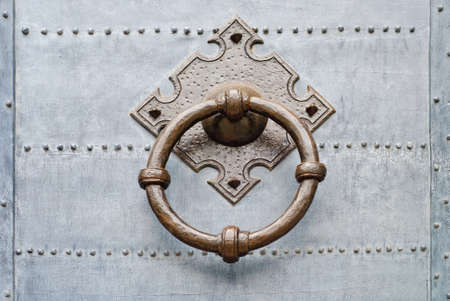 Old door knocker with ring on metalic doorの写真素材