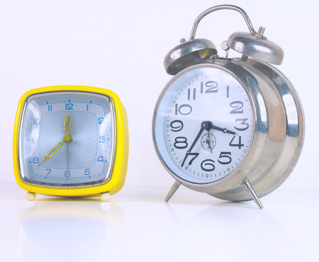 Two vintage alarm clocks isolated on white background